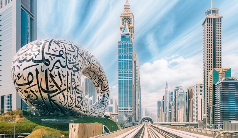 Metro railway among among glass skyscrapers in Dubai. Traffic on street in Dubai. Museum of the Future in Dubai. Cityscape skyline. Urban background.